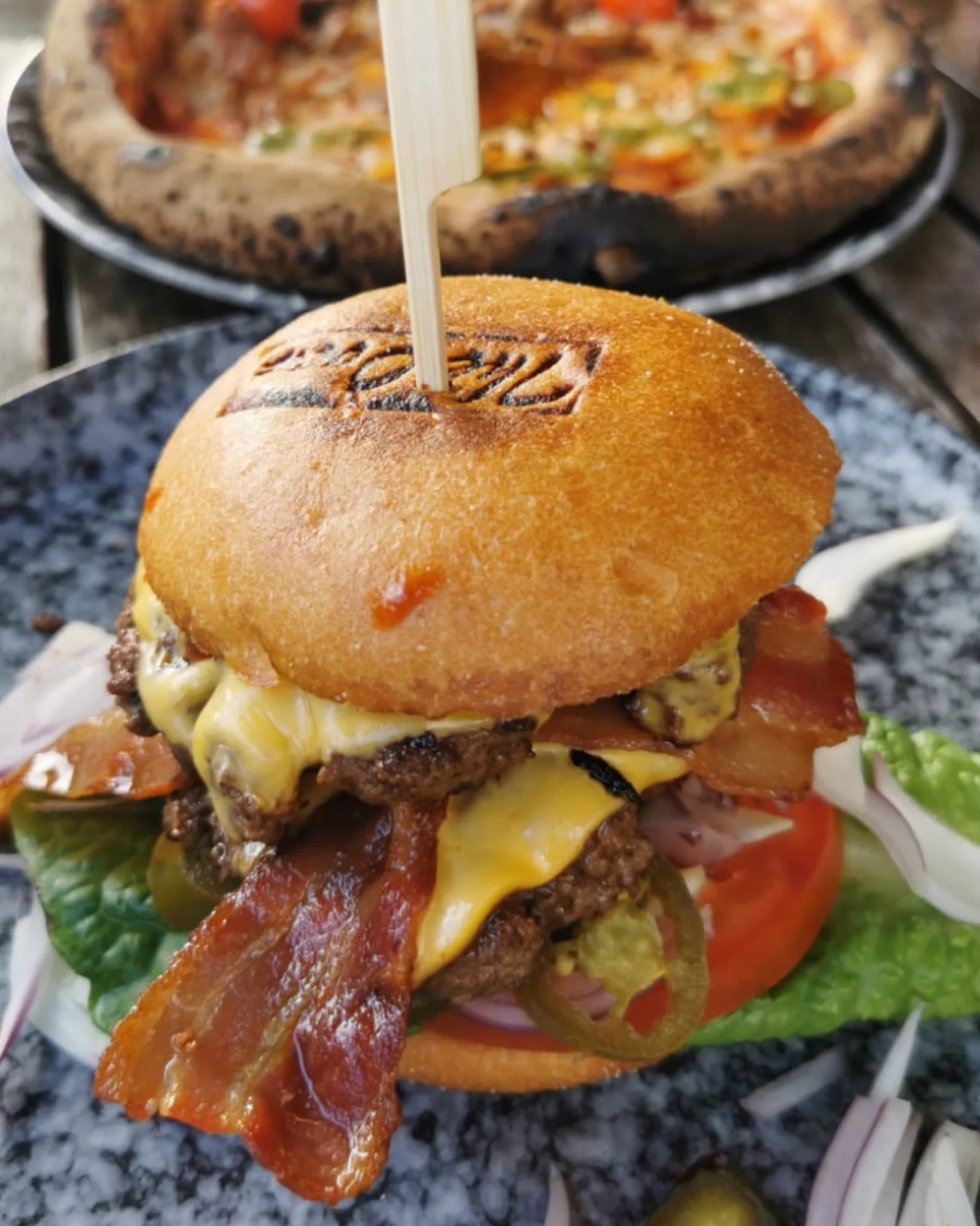 Smashburgare med smält ost, sallad och tomat på briochebröd
